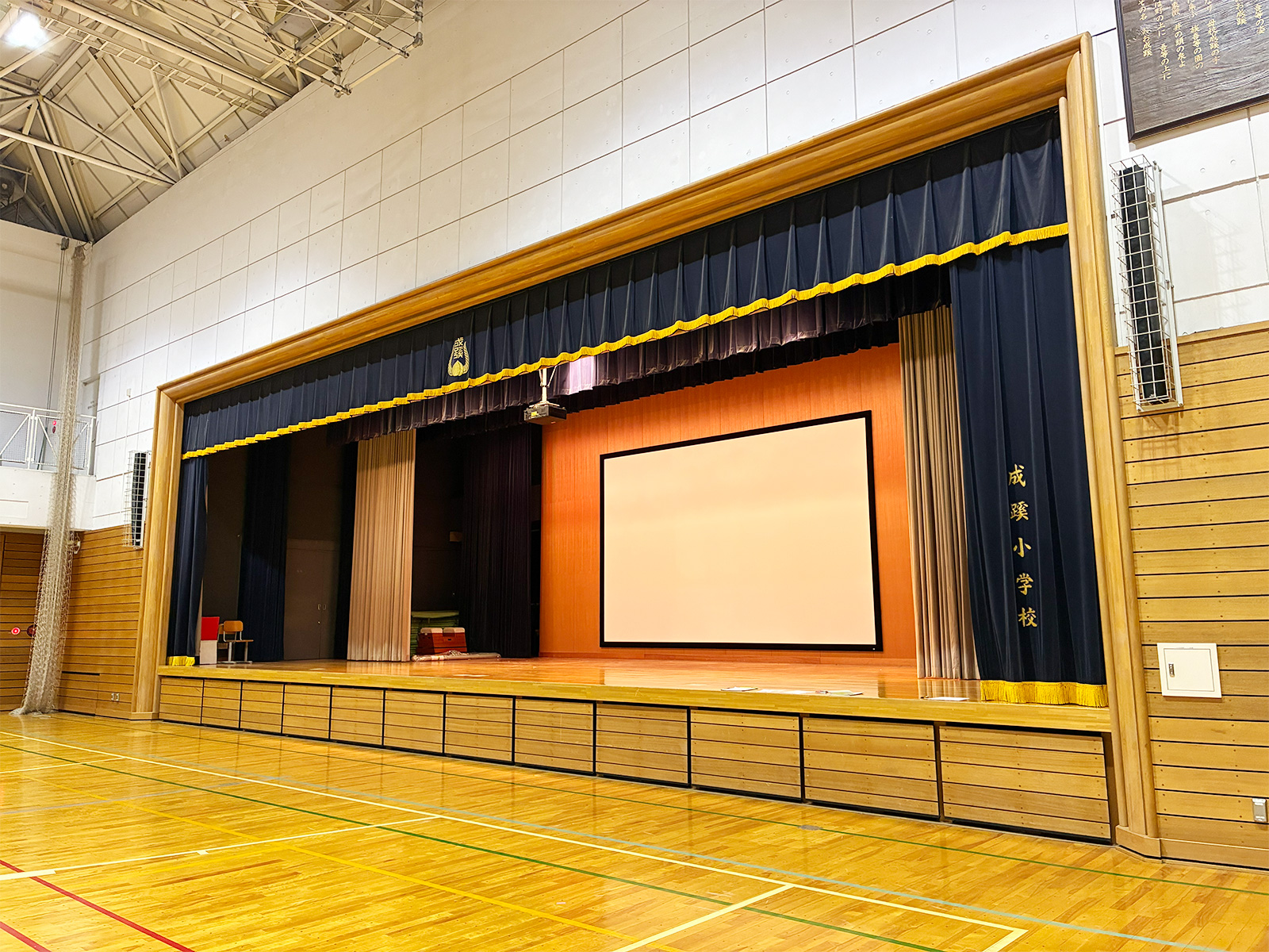 体育館への250インチ大型スクリーン・プロジェクター最適化事例｜成蹊小学校 様を掲載